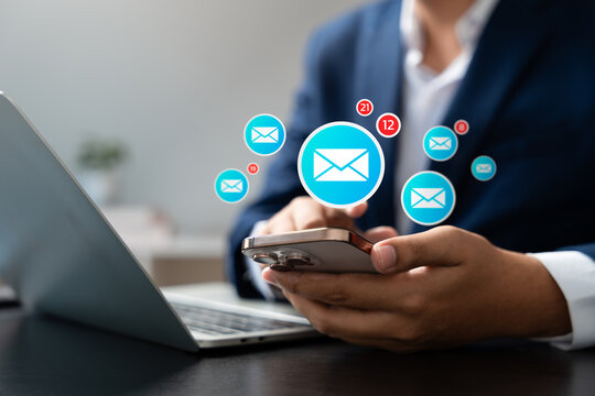 New message notification concept, Businessman checking new email notifications on smartphone with digital icons, representing online communication, instant messaging, and modern workspace connectivity - Powered by Adobe