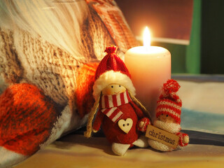 Zum 1. Advent brennt eine Kerze, davor stehen zwei Weihnachtswichtel mit roter Mütze