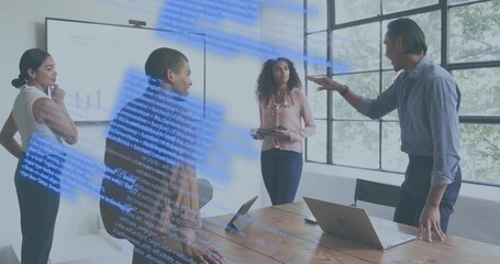 Leaning man in light-blue shirt addressing team at meeting table with screen and tablet, copy space