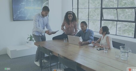 Discussing team in business casual reviewing laptop and tablet at modern office meeting room