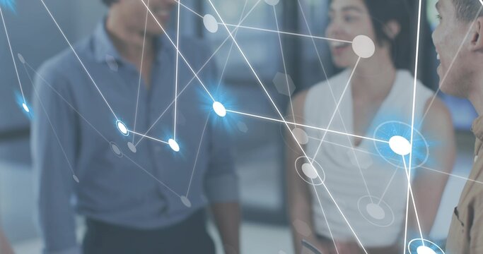 Discussing three coworkers in business casual holding device while viewing hologram in office