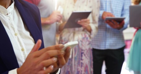 Tapping man in navy blazer, white shirt checking white phone at meeting, with tablets, copy space
