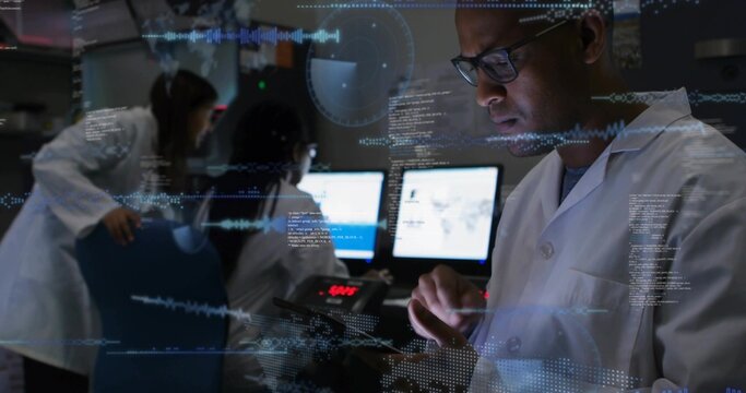 Holding tablet, male researcher in lab coat studying data in lab with dual monitors and overlays