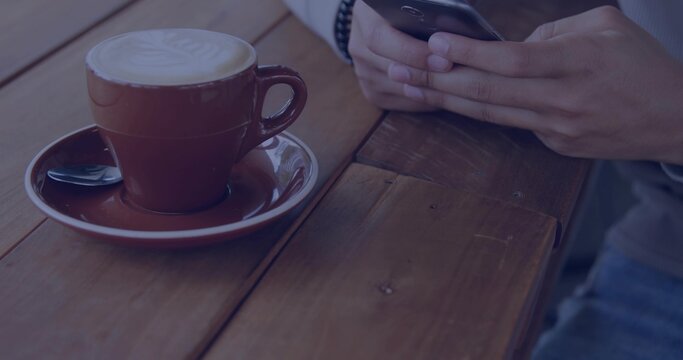 Showing brown latte cup on cafe table, man holding smartphone with bracelet and watch, copy space