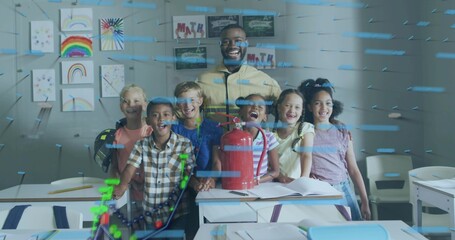 Smiling teacher in yellow jacket guiding six kids around desks in classroom, with red extinguisher