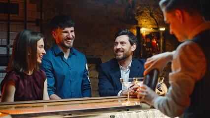 Laughing colleagues ordering alcohol communicating barista at counter closeup