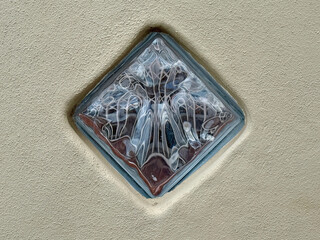 Eingemauerter Glasbaustein mit bunten Reflexionen 