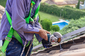 Worker cutting metal structure for solar panel installation