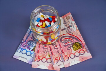 Different capsules, tablets and tenge banknotes. Rising drug prices. Quotas, subsidizing medical...