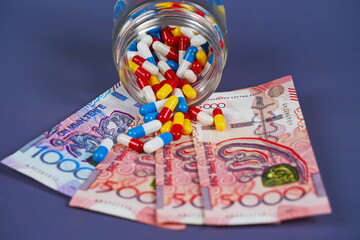 Different capsules, tablets and tenge banknotes. Rising drug prices. Quotas, subsidizing medical...