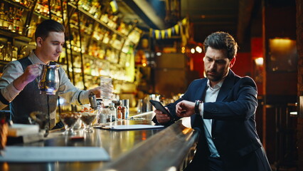 Sad businessman relaxing bar watching smartphone closeup. Man ordering cocktail