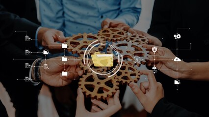 Close-up of diverse hands joining gears, symbolizing teamwork and innovation. Digital elements overlay the image, emphasizing collaboration and strategic planning in business. Raster