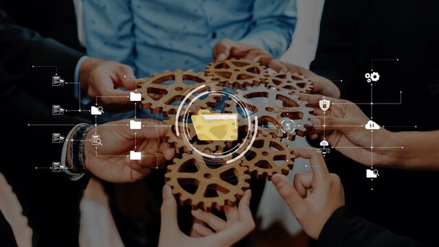 Close-up of diverse hands joining gears, symbolizing teamwork and innovation. Digital elements overlay the image, emphasizing collaboration and strategic planning in business. Raster - Powered by Adobe