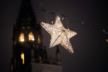 An illuminated star hanging in front of the illuminated tower of the M&uuml;nster unserer lieben Frau at night. Constance, Baden-W&uuml;rttemberg, Germany.