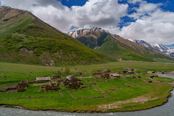 Abandoned riverside village in wide green Caucasus mountain valley