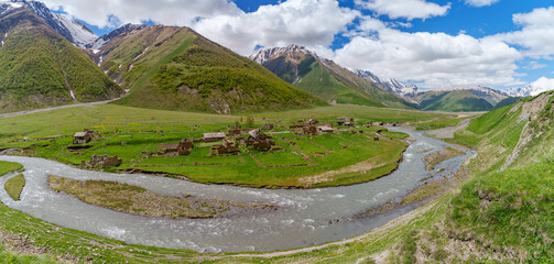 Panoramic view of ruined riverside village in broad Caucasus valley
