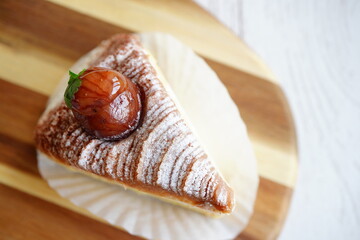 艶のある栗を中央に乗せたモンブランケーキを接写で撮影。パウダーシュガーとクリームの層が美しく、秋のスイーツ提案・カフェメニュー・洋菓子紹介・店舗広告にも使いやすい高品質なスイーツ写真。