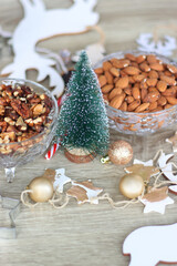 Various Christmas decorations, cookies, chocolate and nuts on wooden background. Selective focus.