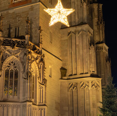 An illuminated star hanging in front of the illuminated tower walls of the M&uuml;nster unserer lieben Frau at night. Constance, Baden-W&uuml;rttemberg, Germany.
