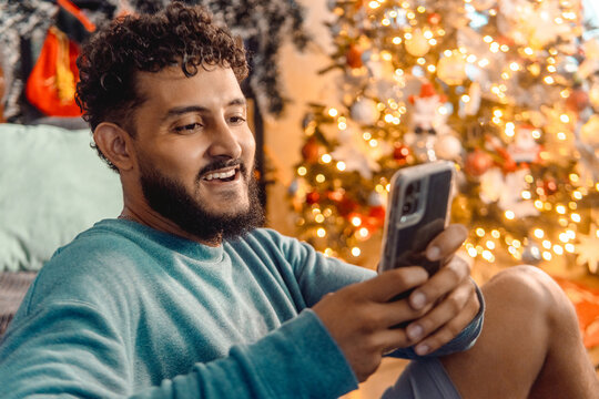 Man enjoying holiday video call near christmas tree