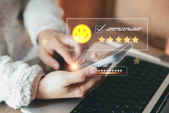 Business person using smartphone and laptop for giving online feedback and customer review. Concept of digital rating, mobile technology, service satisfaction, and user experience.