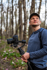 Man photographer holding camera gimbal for pink trillium wildflowers flowers field in Virginia Blue Ridge of Wintergreen Resort
