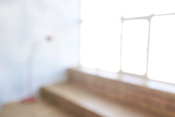 Abstract blur of cozy room with bright windows, soft lighting, and wooden details.