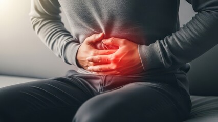 Man clutching stomach in pain due to abdominal discomfort, stomachache, or digestive issue
