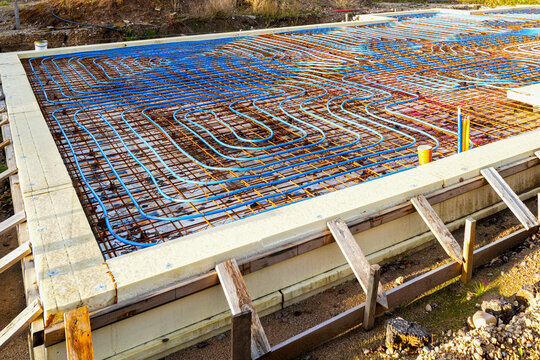 Underfloor heating pipes over reinforced rebar grid before concrete foundation slab pouring