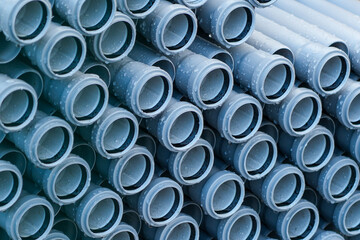 Stacked PVC pipes with water droplets ready for installation at construction or plumbing site