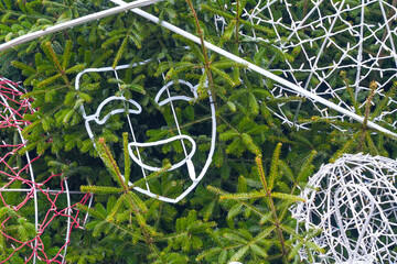 Festive Christmas tree with illuminated wire decorations and glowing holiday ornaments outdoors