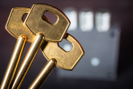 Background with golden keys held in focus against a blurred lock mechanism, creating a security-themed composition for design, branding, or promotional materials.