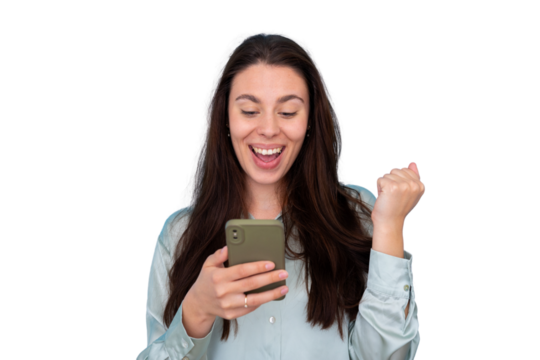Woman holding a smartphone, looking at its screen with an excited facial expression and clenching her fist, celebrating a win