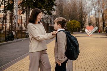 a mother seeing off or meeting her child at school, a parent with a student at school