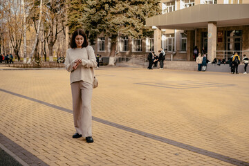 Obraz premium a girl is looking at her watch outside, waiting for someone