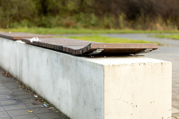 Unique park bench design with wooden seating on a concrete base