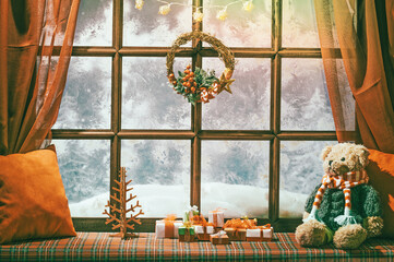christmas cozy interior background with window sill illuminated with lights and bear toy