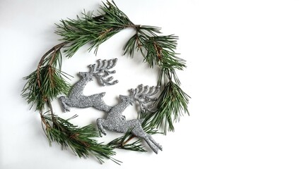 A wreath of live needles on a white background with silver glitter deer, a Christmas card with toys
