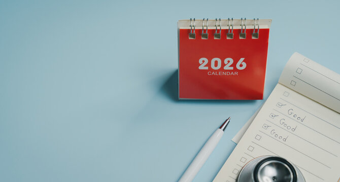 2026 calendar with white pen and checklist notepad on light blue surface, showing handwritten notes and stethoscope for professional or medical setting