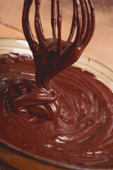 a bowl of chocolate dough, a whisk for whipping, baking, structure and consistency, homemade, top view, no people,
