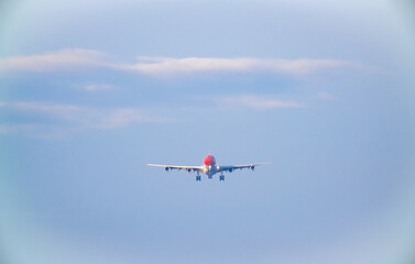 The plane lands over the sea at Phuket airport. A passenger plane lands on Mai Khao Beach, a popular tourist attraction.