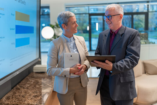 Business colleagues discussing data using digital tablets