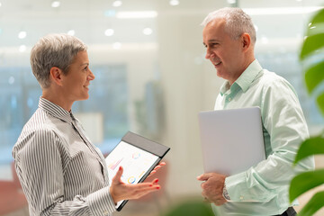 Business colleagues discussing data on tablet in office