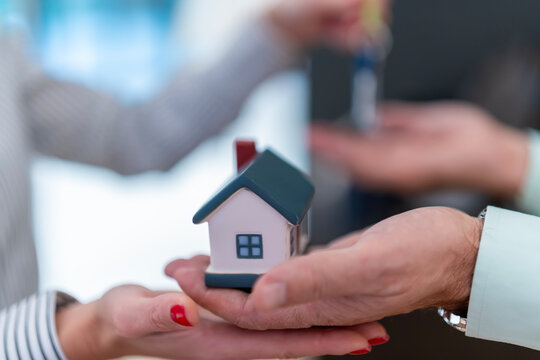 Couple receiving miniature house and keys during real estate transaction