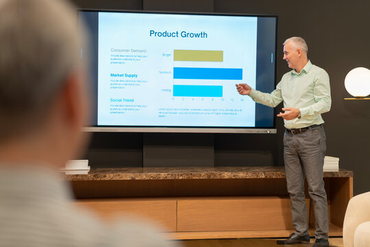 Senior businessman giving product growth presentation to audience