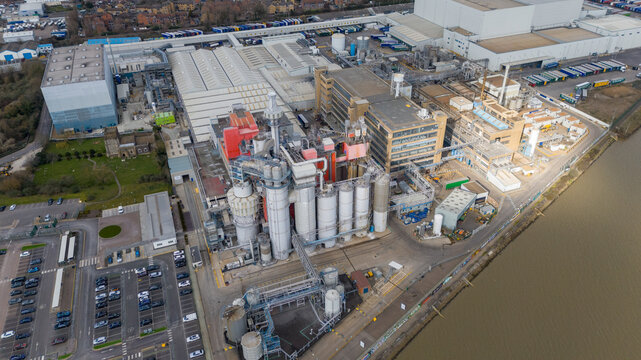 Procter & Gamble, United Kingdom - 15 March 2025: Aerial view of the industrial complex with stark contrasts between the modern buildings and the muddy riverbank.