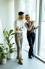 Discussing ideas by the window in a modern office setting during daylight hours