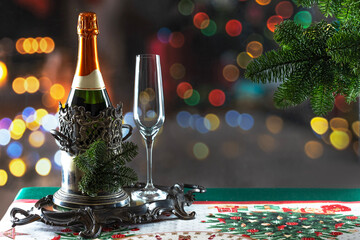 Bottle of champagne in an ice bucket on the New Year's table. Christmas and New Year celebration with champagne. The concept of the holiday.