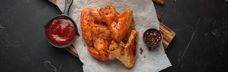 Roasted grilled chicken wings dipping sauce ketchup wooden cutting board barbecue bbq