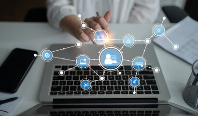 A user interacts with a laptop in a modern workspace. Digital network icons symbolize connectivity, innovation, and communication in a professional environment. Tessel